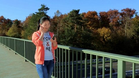 一个年轻女孩快乐的带着耳机听歌